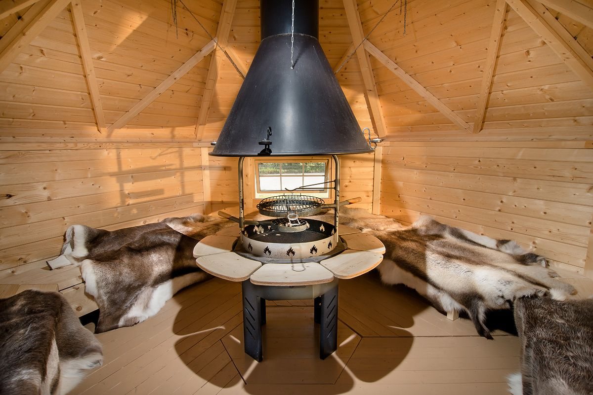 Interior of a timber BBQ hut with central grill hood and bench seating | Signature Garden Rooms, Central Scotland