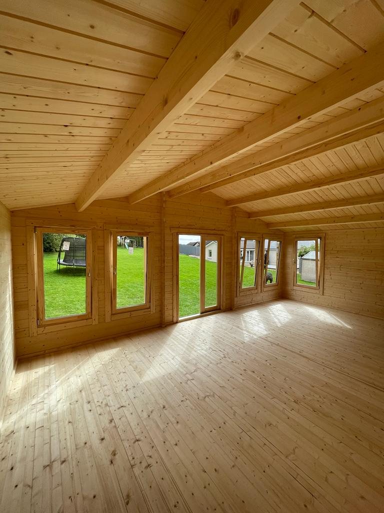 Empty timber log cabin interior showing exposed roof beams and floor | Signature Garden Rooms, Central Scotland