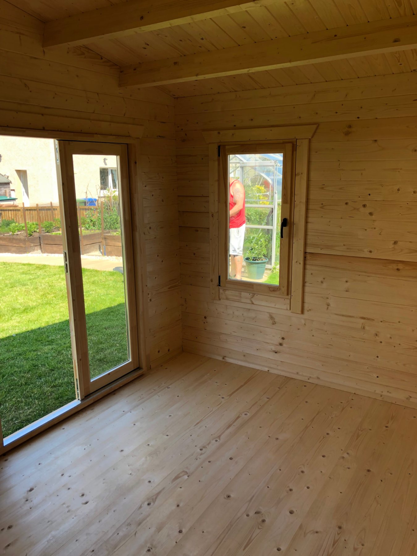Interior view of an empty timber log cabin featuring natural wood walls and doors | Signature Garden Rooms, Central Scotland