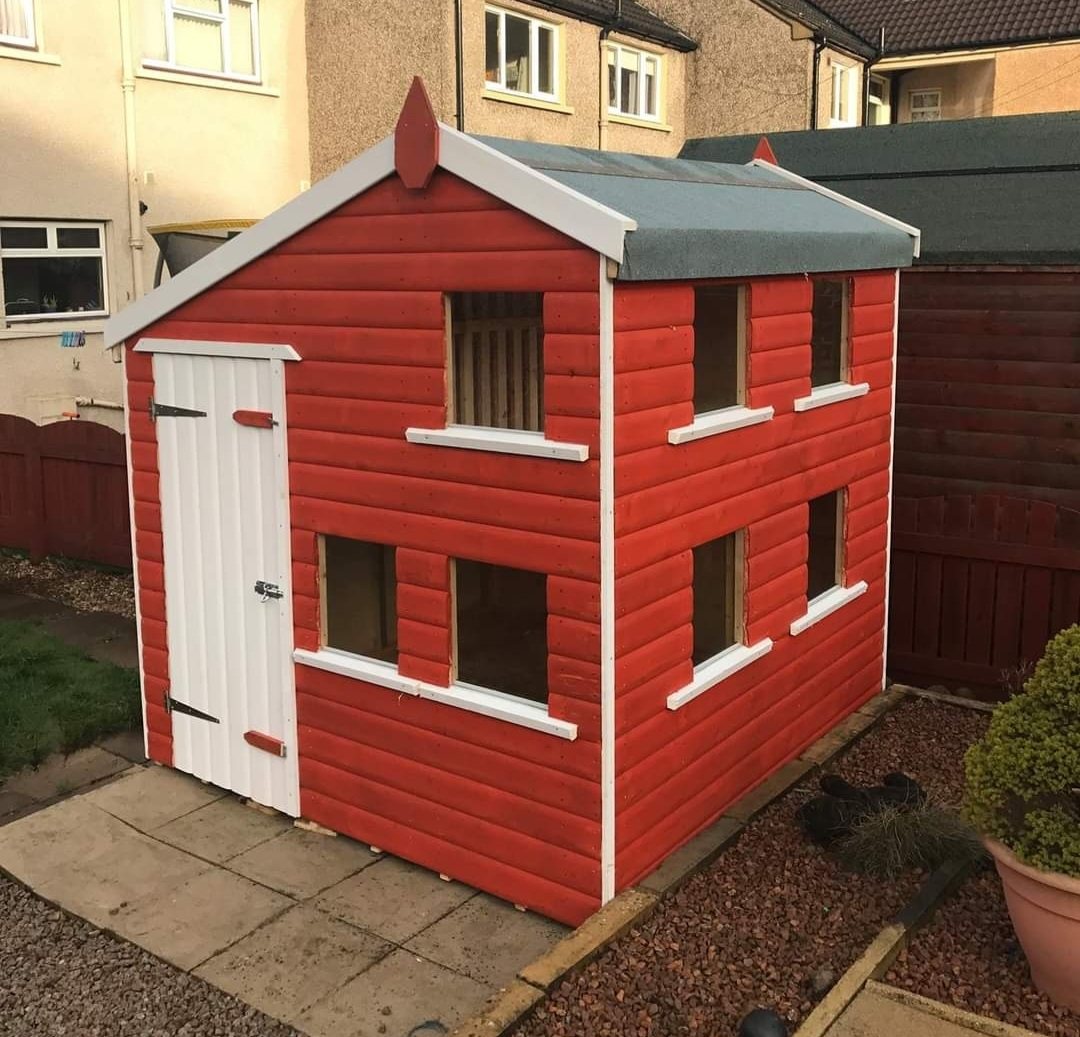 Red and white two-storey wooden children's playhouse in a backyard garden | Signature Garden Rooms, Central Scotland