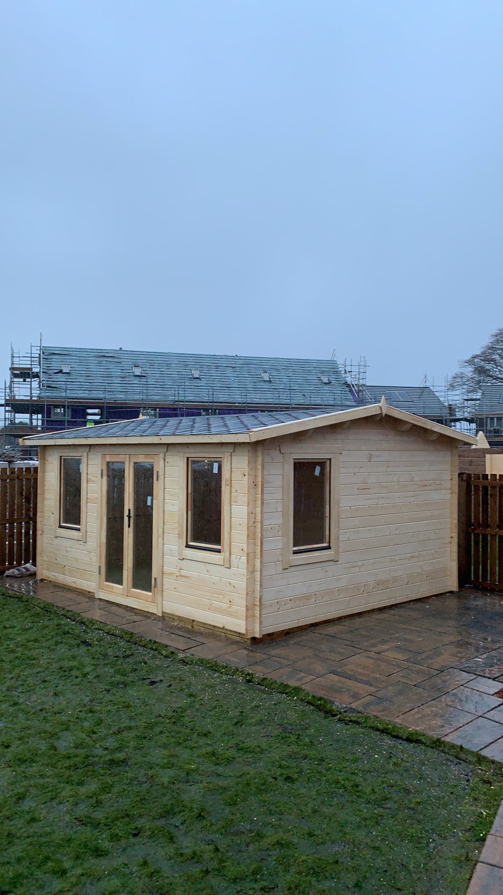 Natural wood log cabin with double glass doors installed on a patio area | Signature Garden Rooms, Central Scotland